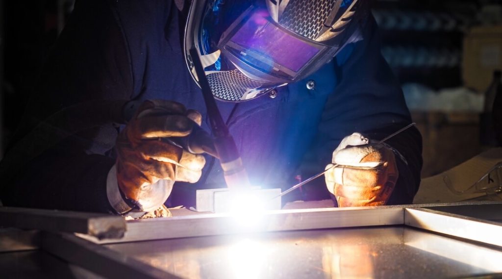 Un soudeur qualifié effectuant une soudure TIG précise sur un joint en aluminium, illustrant les meilleures pratiques pour des soudures propres et solides.